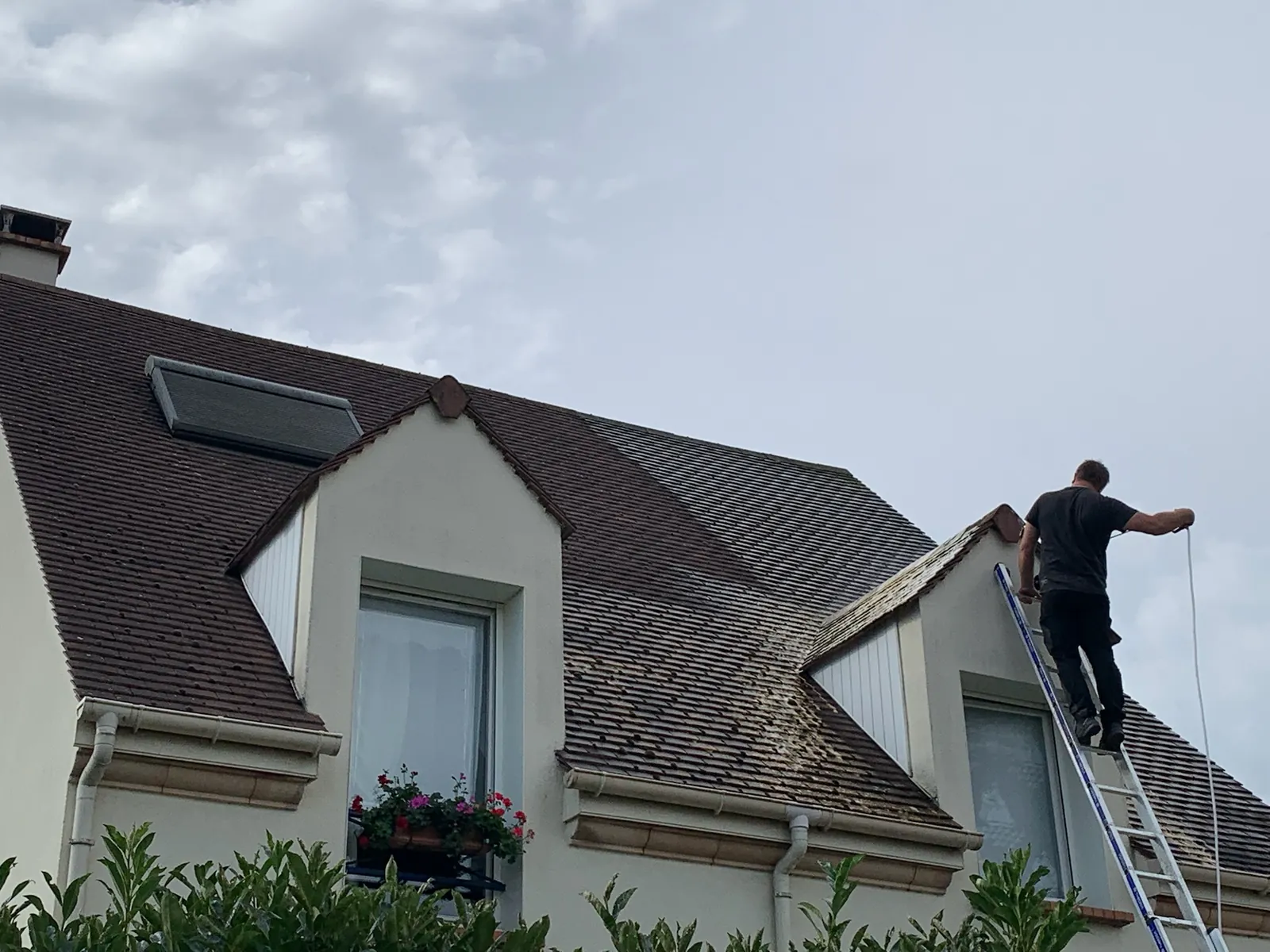 L'artisan sur son échelle pour le nettoyage d'une toiture — M. Simonard, couvreur à Bry-sur-Marne