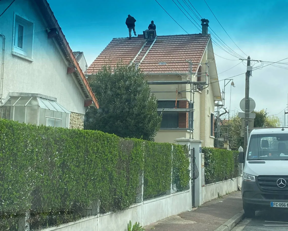 Véhicule Simonard devant une maison dont la toiture est en rénovation — M. Simonard, couvreur au Perreux-sur-Marne